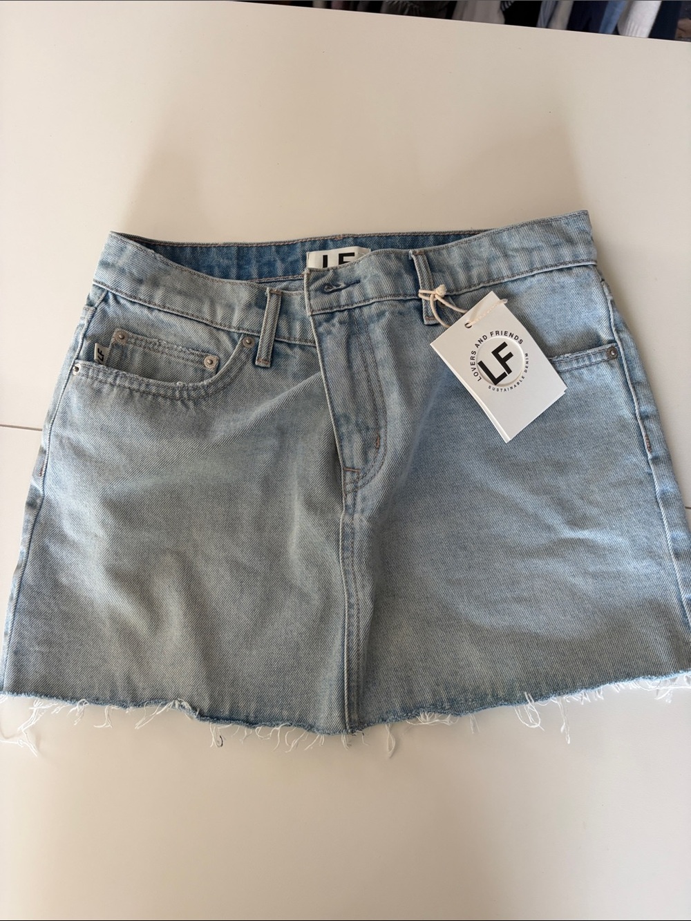 Lovers + Friends Light Wash Denim Mini Skirt with Raw Hem
